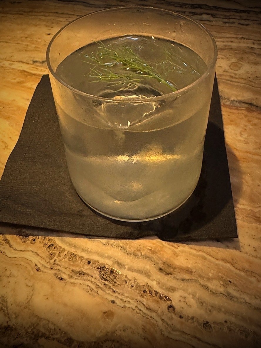 Clarified mezcal margarita with fennel frond garnish in frosted glass